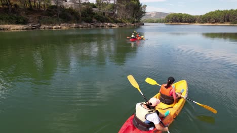 family fun, enjoying riding colorful kakacs in a green water lake in castellon, spain