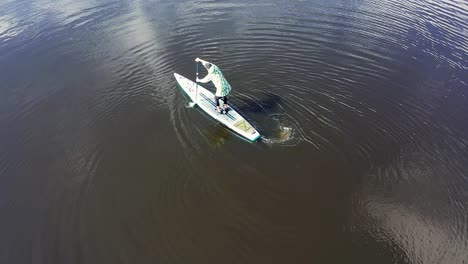 person paddleboarding on a calm river