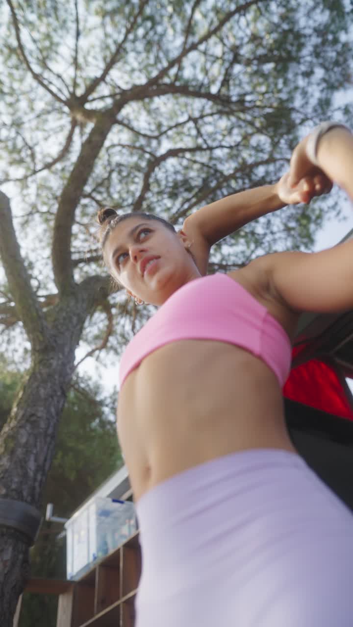 Young Woman Stretching Outdoors Under a Tree