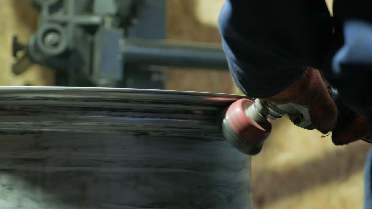el maestro de reparación de carrocería está trabajando en la preparación de la superficie de la rueda de aluminio del automóvil para su posterior pintura en el taller, limpiando y nivelando la rueda