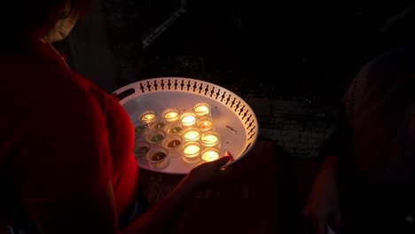 turning on various candles at a dia de los muertos celebration in the dominican republic