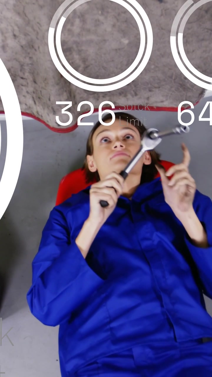 Dikey video: Sandalyede yatan tamirci İngiliz anahtarı alıyor, HUD sayaçları güncellenirken yukarıyı tamir ediyor.