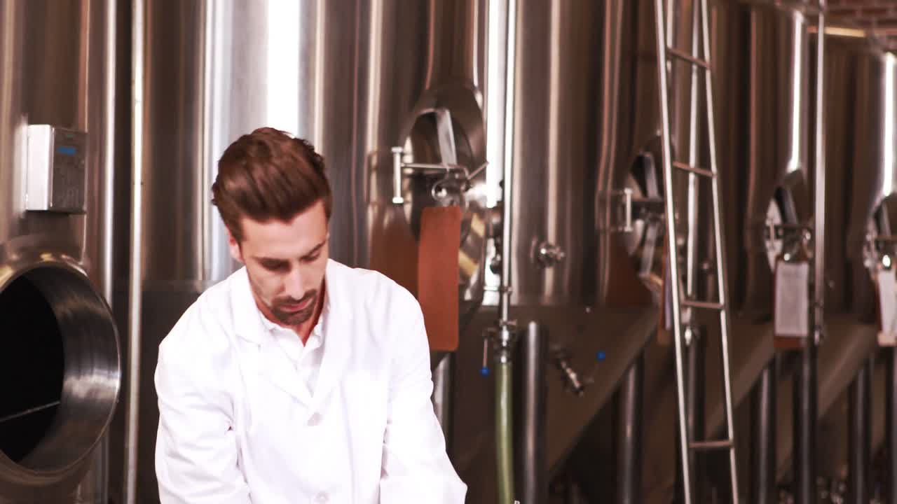 Focused scientist looking beaker with beer