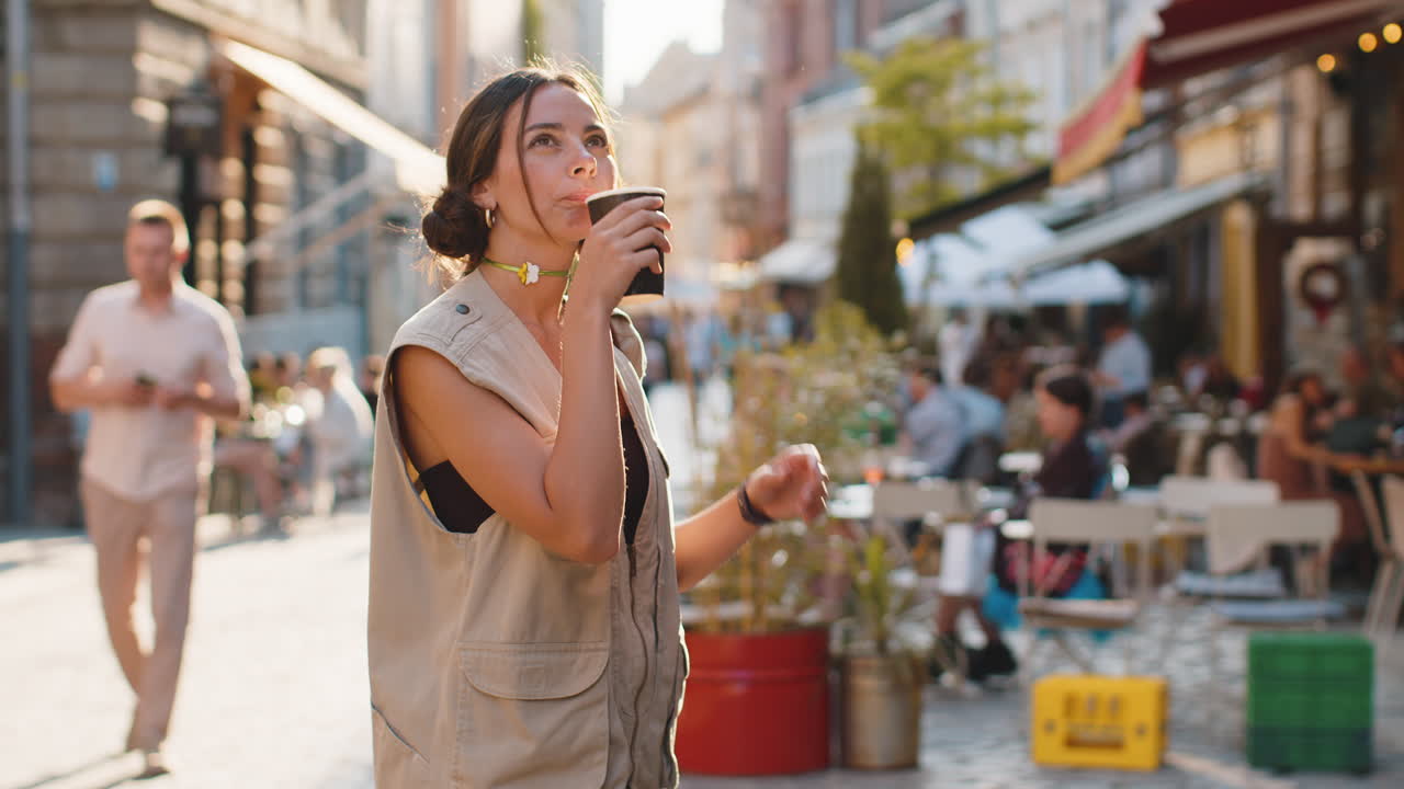 Junge Frau genießt ihren Morgenkaffee, entspannt sich und macht eine Pause auf der Stadtstraße.