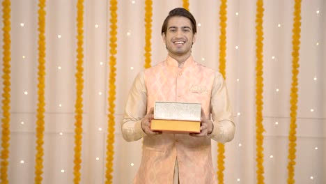 Indian-man-offering-sweet-boxes