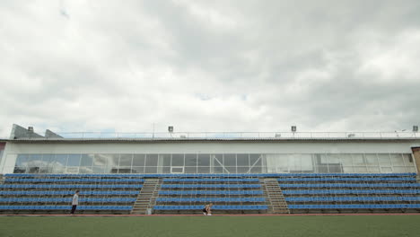 people running on a cloudy day at an empty stadium