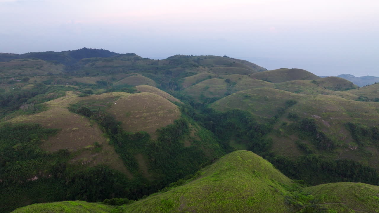 vista aérea de las exuberantes colinas verdes de bukit teletubbies en nusa penida, bali, indonesia durante la puesta del sol