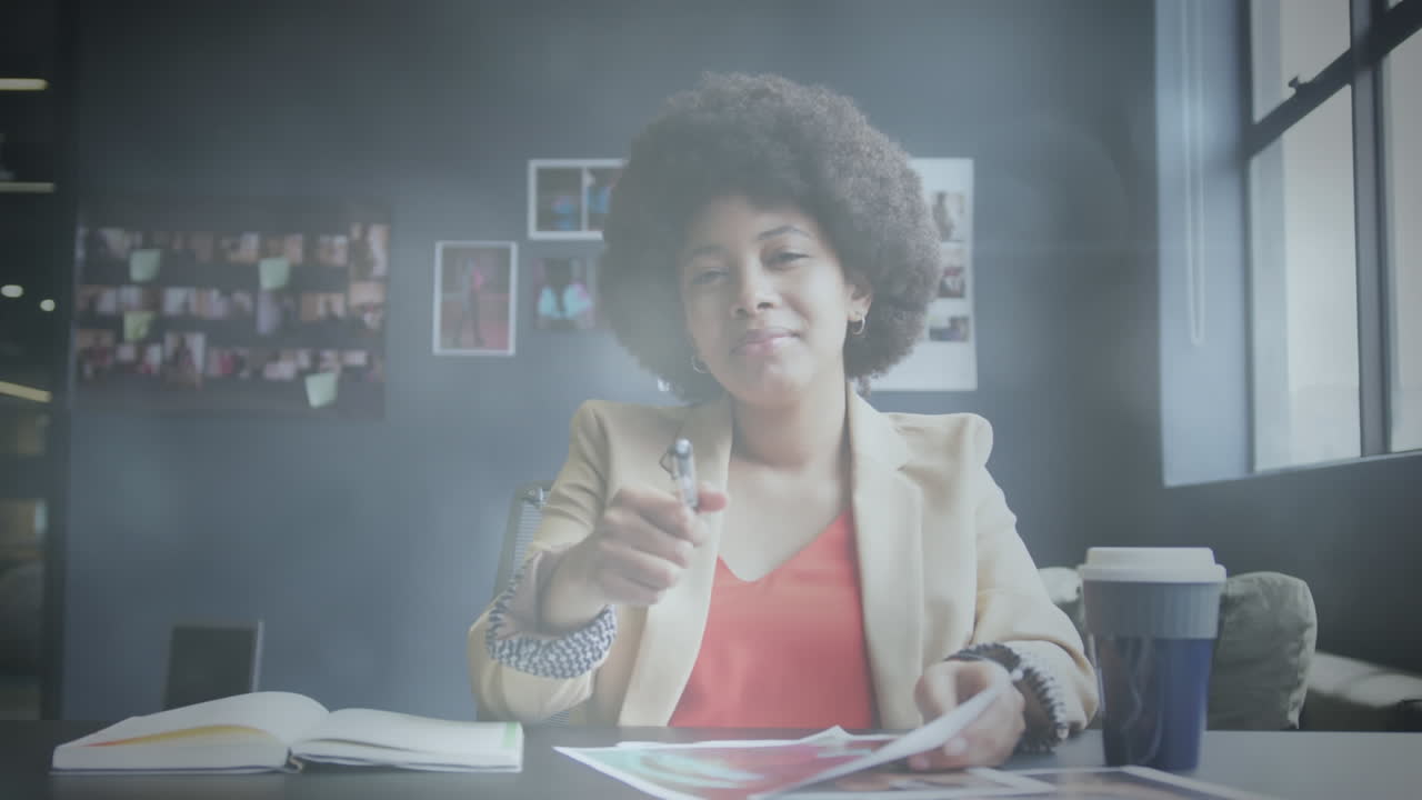 animación de puntos de luz sobre una mujer de negocios afroamericana haciendo una videollamada y sonriendo