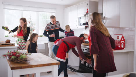 Padre-Sacando-El-Pavo-Del-Horno-Mientras-La-Familia-Celebra-La-Navidad-Juntos-En-Casa