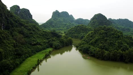 Drone-Ascendiendo-Sobre-El-Parque-De-Aves-Ninh-Binh-Con-Fondo-De-Montañas-Kársticas-En-Vietnam