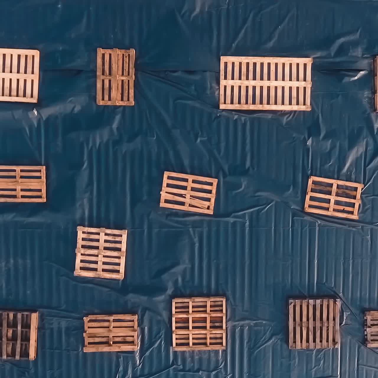 Many wooden crates on the roof of a big building. Empty wooden boxes of different sizes on the blue background. Top view.