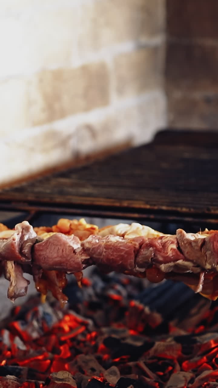 Cooking delicious meat on charcoal. Meat on skewers. Marinated shashlik preparing on a barbecue grill. Appetizing meat grilled on skewers. Vertical video