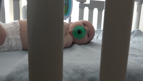 A-swaddled-baby-sucking-on-a-pacifier-in-a-hospital-crib