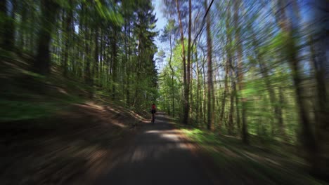 a rear view of the female cyclist riding a bicycle in the divoka sarka nature reserve in pague