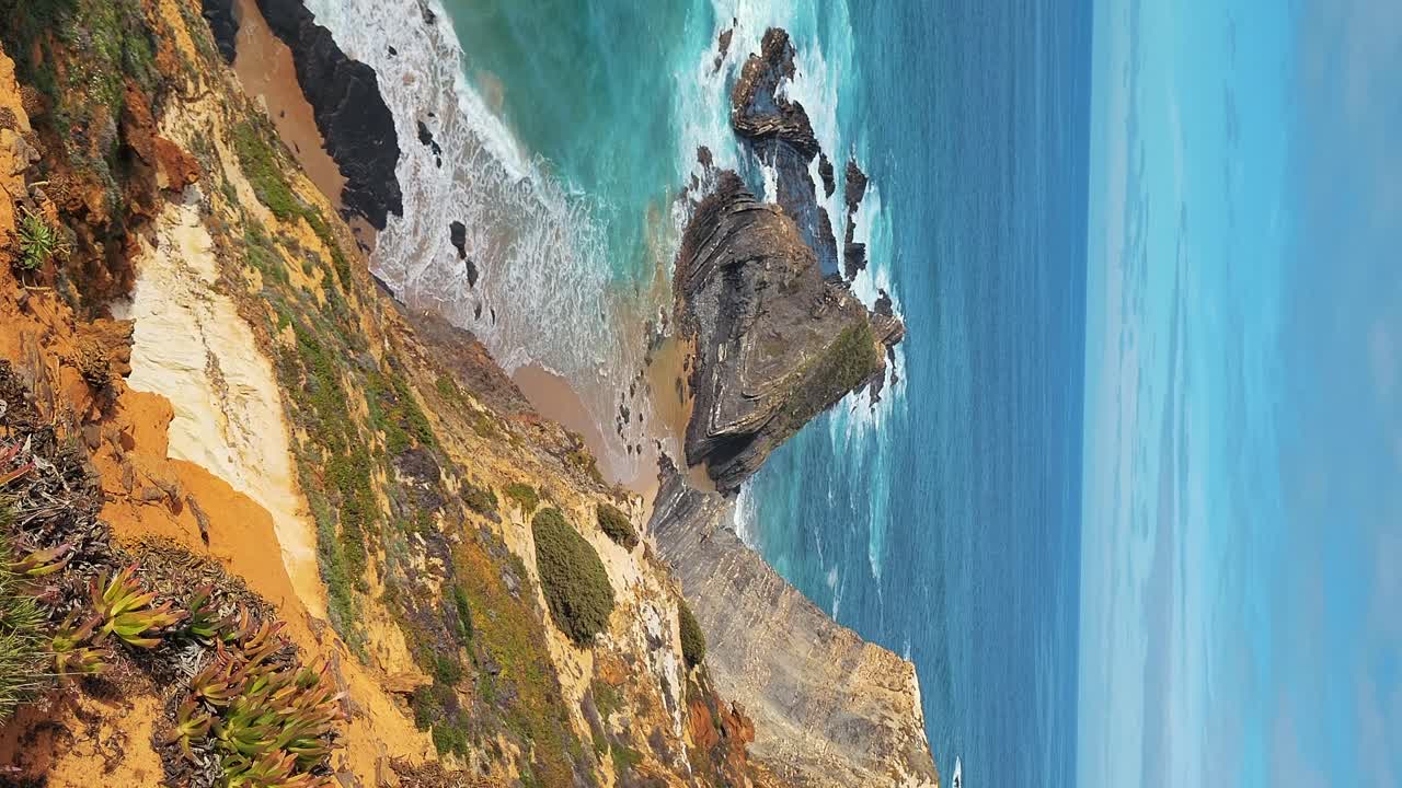 La spiaggia di Almograve con rocce di basalto nero sulla costa dell'Alentejo, Portogallo.