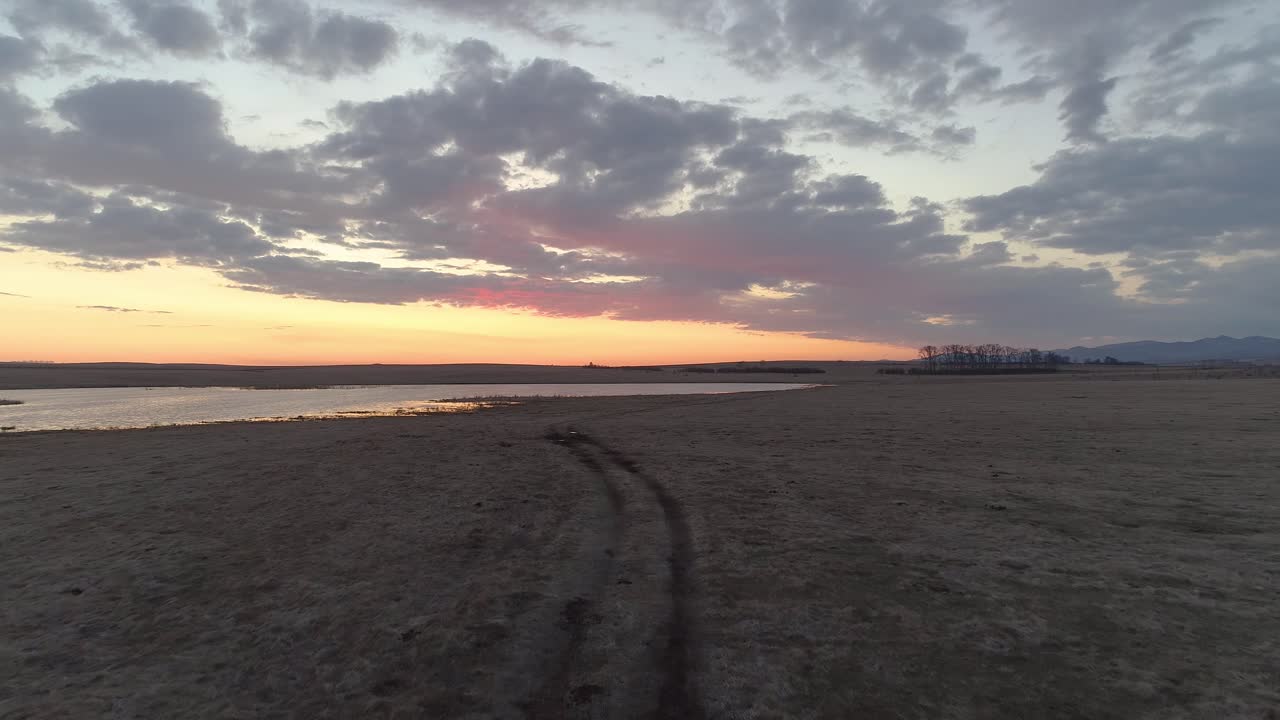 impresionante puesta de sol sobre un campo y un lago