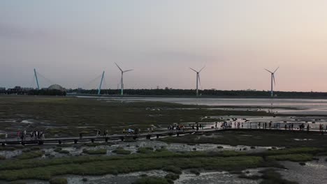 電影空中追蹤拍攝在高梅湿地保護區的風力輪在日落時旋轉和旋轉在地平線,台中,台灣