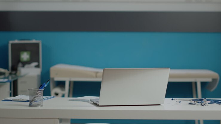 Close up of white desk with laptop and medical instruments