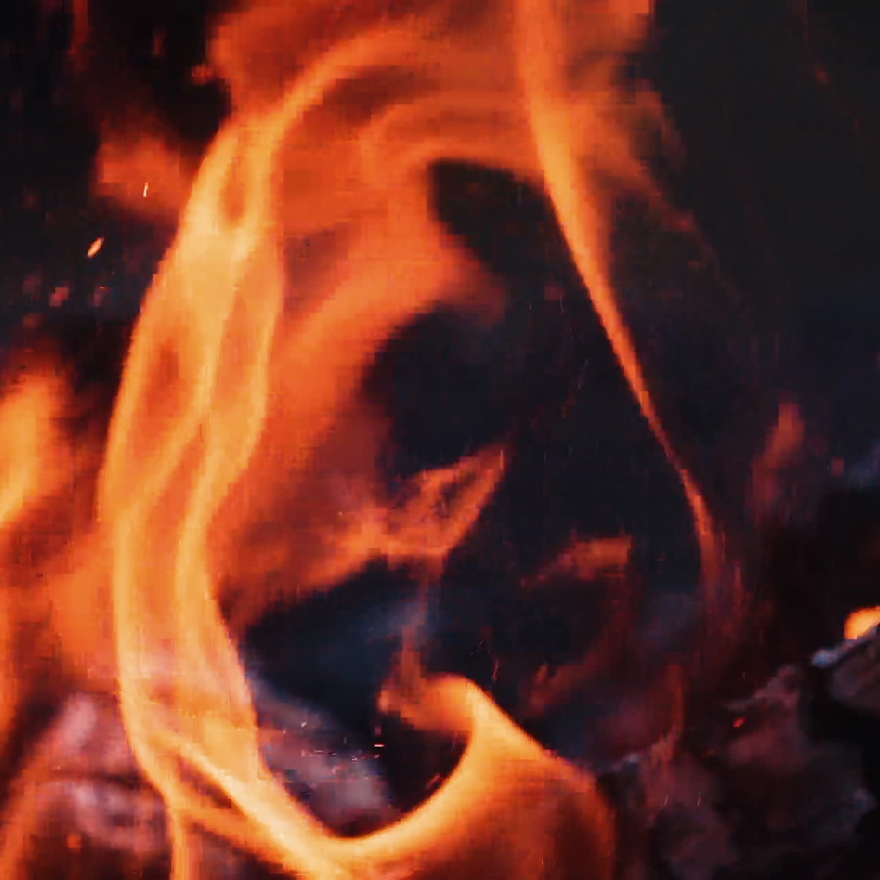 Fuoco ardente. Legna che brucia luminosa al rallentatore. Schizzi di fiamma e braci vive