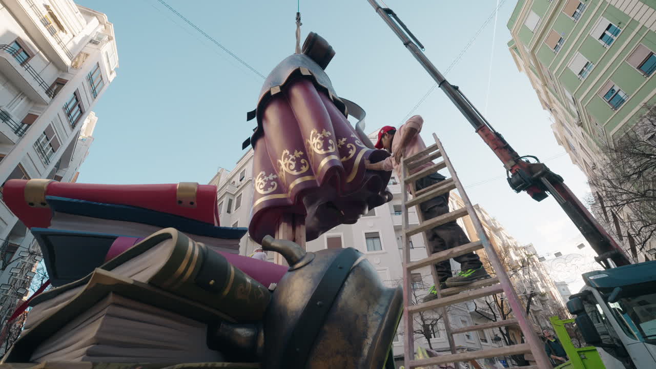 Gadeinstallation af et Fallas-monument i Valencia, Spanien. Arbejdere samler den store skulptur før den officielle “plantà” under Las Fallas-festivalen