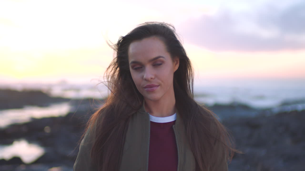 En ung kvinde slapper af på stranden ved solnedgang