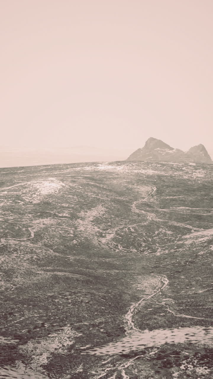 Misty landscape reveals rugged mountains and textured terrain in winter light