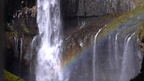 slide reveal of beautiful tall waterfall with rainbow