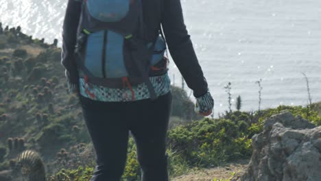 girl hiking on a high cliff near the ocean