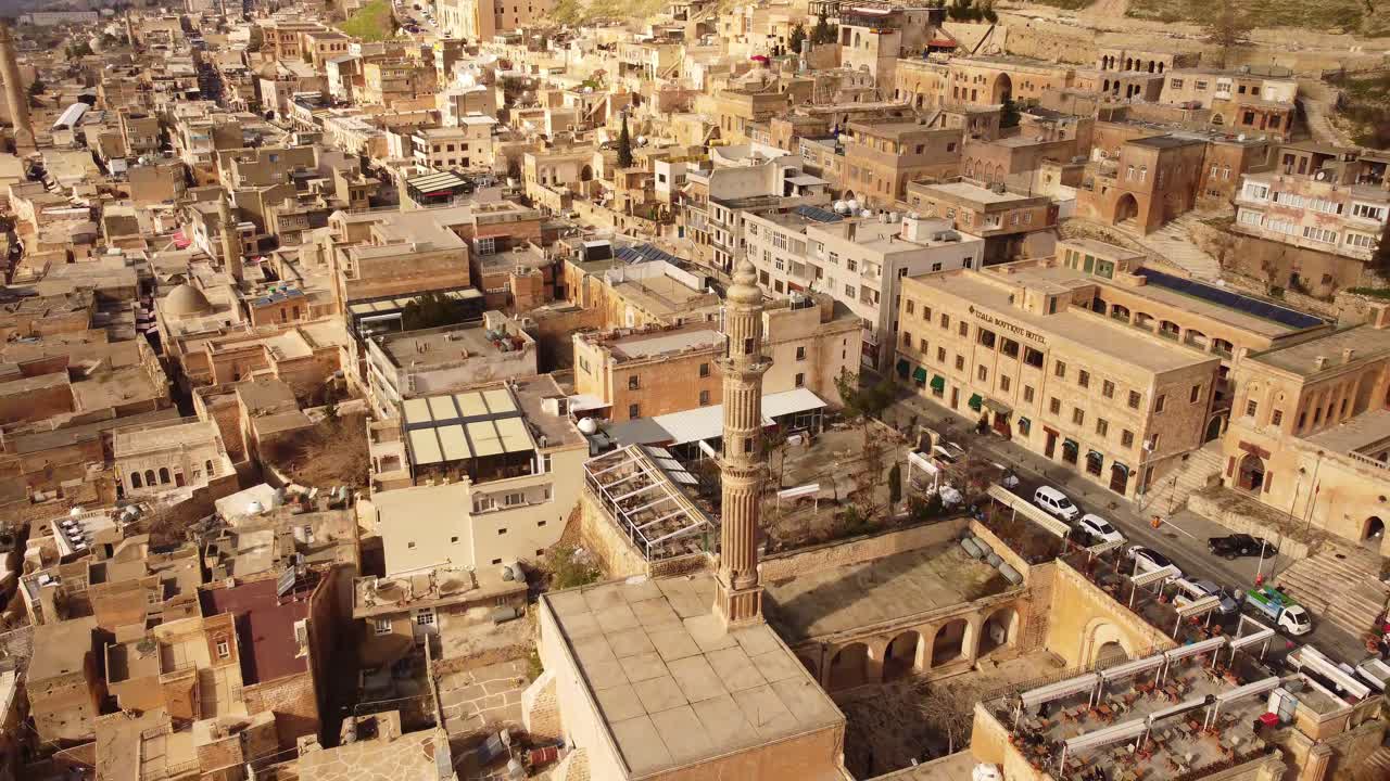Veduta aerea con drone della città vecchia di Mardin, Turchia, edifici in pietra densi e alto minareto, paesaggio urbano storico, patrimonio culturale e destinazione di viaggio.