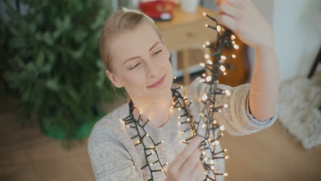 mujer con luces iluminadas para la decoración de navidad