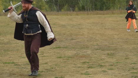 squire with sword and girl with ax walk across lawn talking