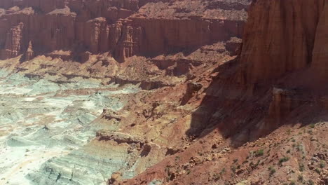 AERIAL---Epic-shot-of-a-very-dry-desert-valley-with-mesas-and-cliffs,-forward