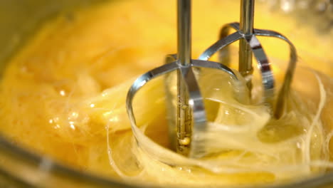 whisk in glass bowl of raw egg