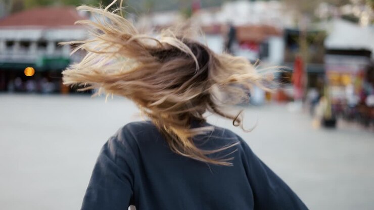 Giovane donna felice che balla all'aperto, si volta per esprimere emozioni positive.