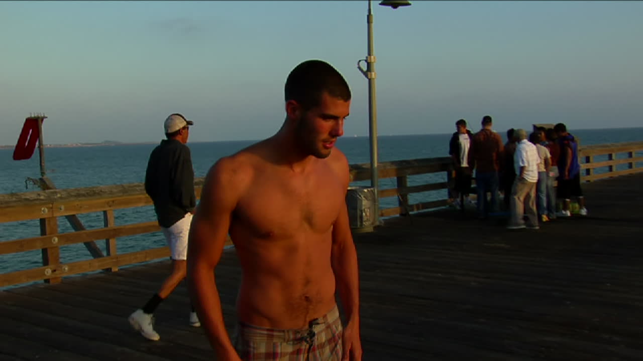 한 젊은이가 부두의 난간을 타고 바다로 뛰어든다