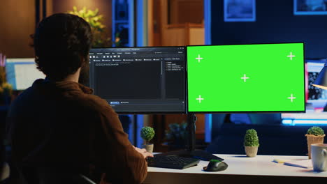 software programmer writing lines of code on chroma key computer at home