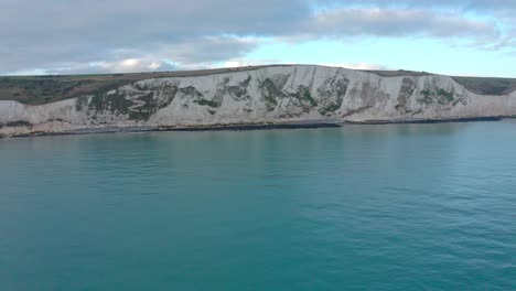 rising aerial drone shot from the sea towards the white cliffs of dover