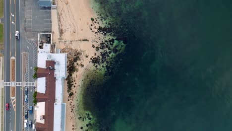 An-aerial,-top-down-view-over-the-waterfront-properties-and-beach-of-the-Long-Island-Sound-in-Greenport,-New-York-on-a-sunny-day