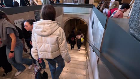 people walking down stairs at the louvre