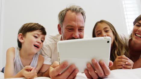 Family-using-digital-tablet-in-bedroom