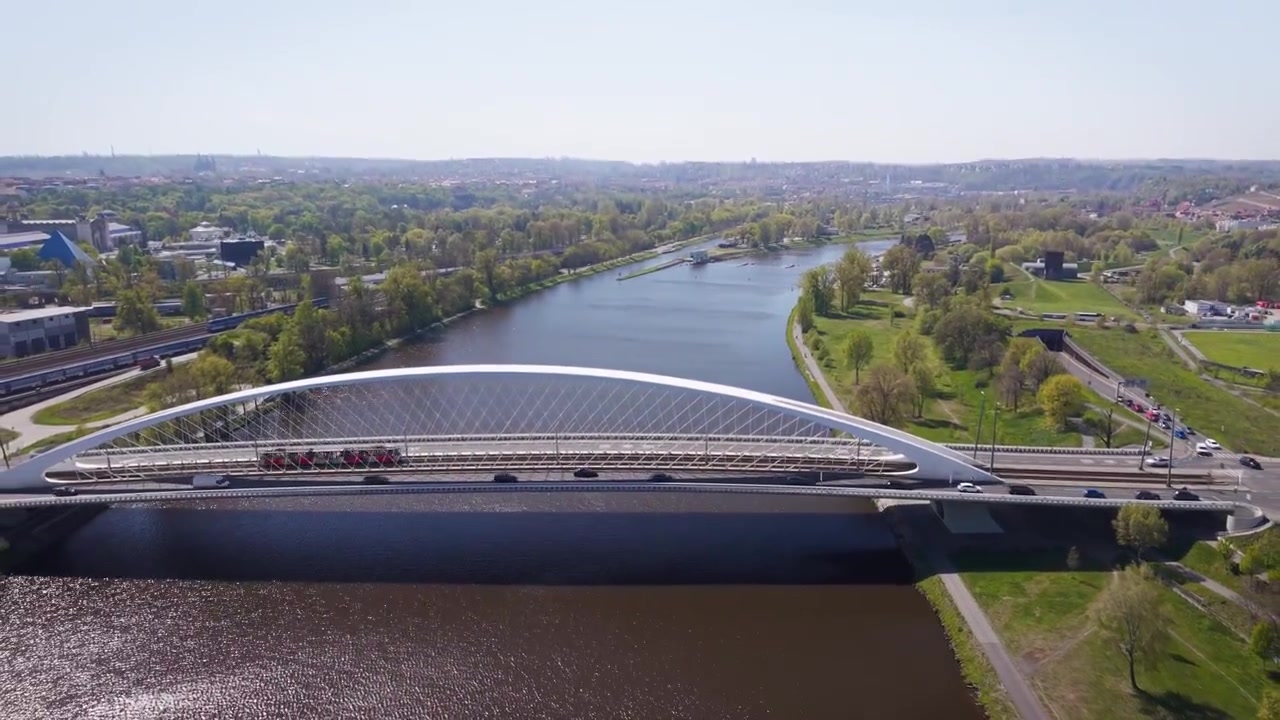 Vista aerea del moderno Ponte di Troja con tram e autobus del trasporto pubblico che attraversano il fiume Moldava verso il quartiere di Holešovice a Praga in una giornata di sole.