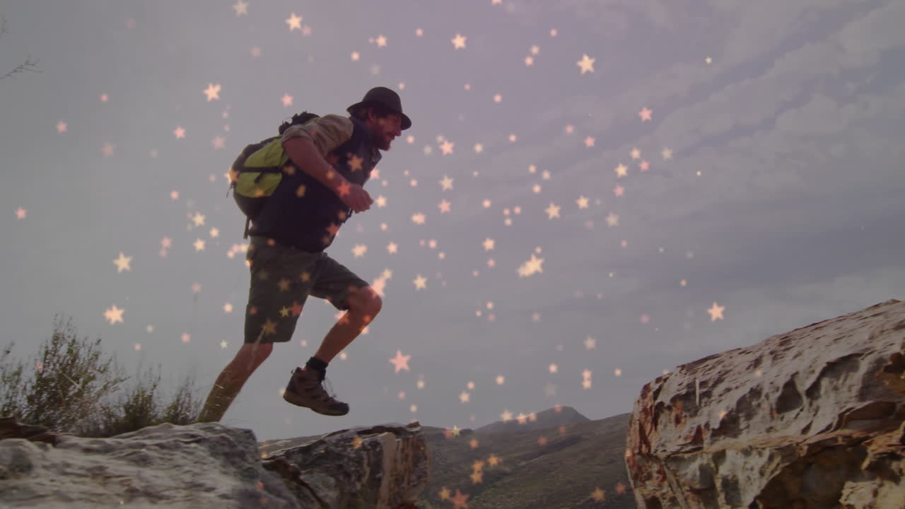 Male hiker climbing rocky hillside under star-like lights, showcasing health data graphics