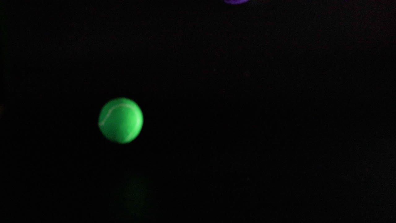 Tennis balls bouncing in dark environment