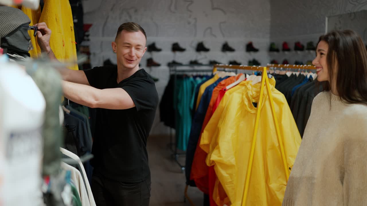 una encantadora pareja de compras en el centro comercial, probando gafas de sol del muñeco, divirtiéndose