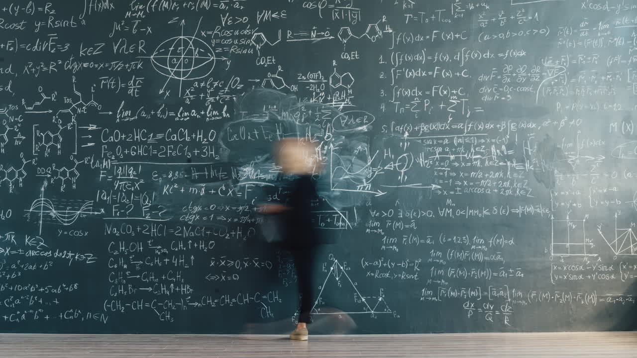 Woman standing in front of a chalkboard covered in complex mathematical equations