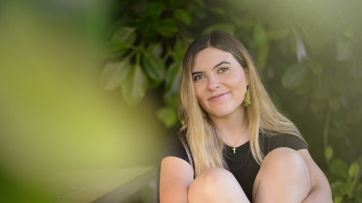 Mujer rubia atrevida lanza un beso a la cámara y se ríe