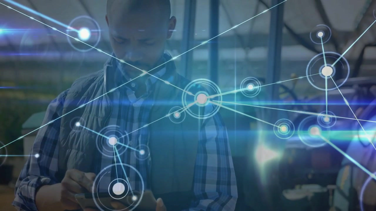 Tapping tech in plaid shirt, vest, scrolling tablet in workshop, causing holo network over gear
