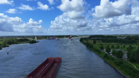 moving-empty-garbage-scow-on-the-river-in-Zwijndrecht,-aerial-tracking