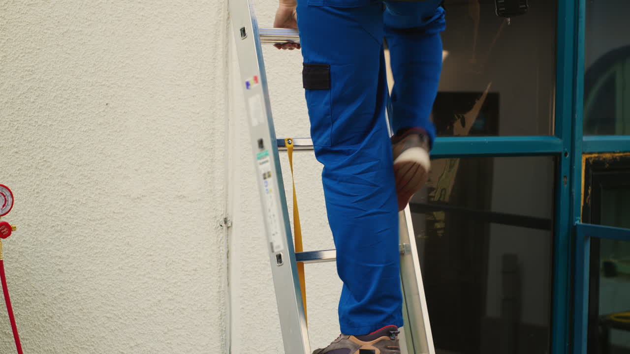Repairman climbing folding ladder
