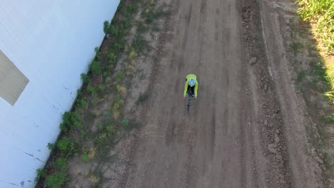 un ciclista pasa de la sombra protectora de un edificio a las largas sombras de la madrugada